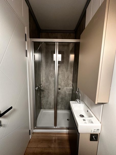 Baño completo con ducha acristalada Baño moderno con ducha de vidrio y lavabo en tonos neutros.