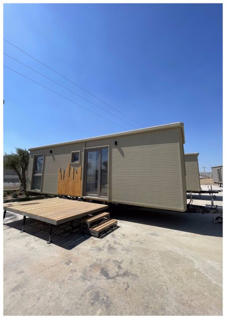 Casa móvil con terraza, escaleras y ventanas en un día soleado.